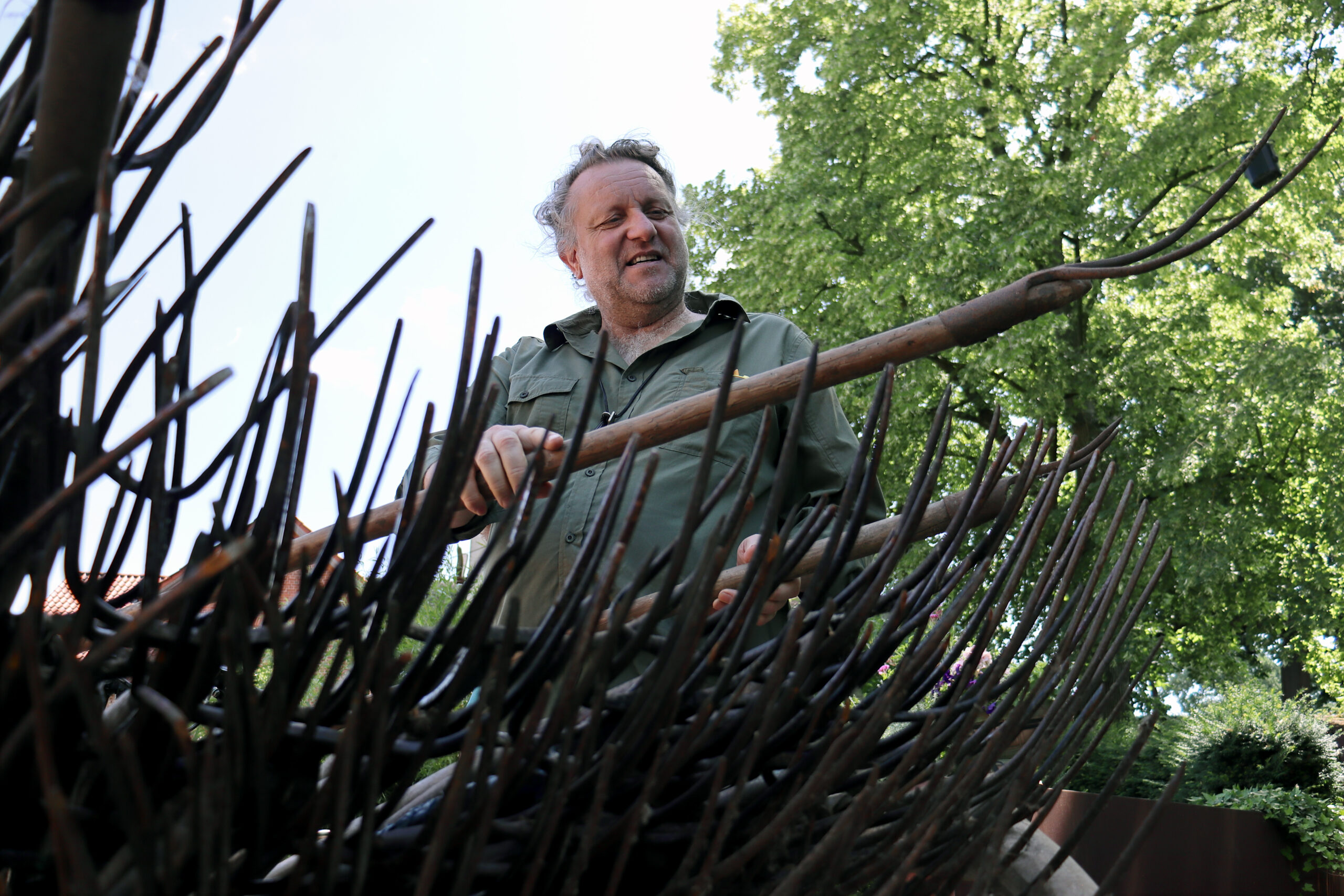 Bild Künstler Volker-Johannes Trieb betrachtet einen Stapel Forken
